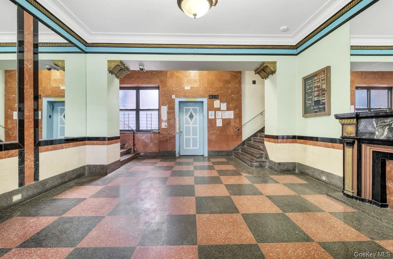 40-05 Ithaca Street, Unit 6D Queens, NY 11373 - Photo 4 of 10 Entrance foyer featuring stairs, ornamental molding, elevator, tile walls, and dark flooring