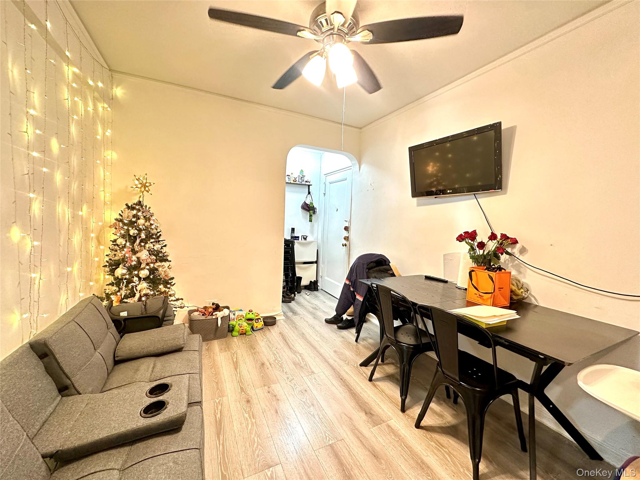40-05 Ithaca Street, Unit 6D Queens, NY 11373 - Photo 6 of 10 Living room with arched walkways, wood finished floors, a ceiling fan, and ornamental molding