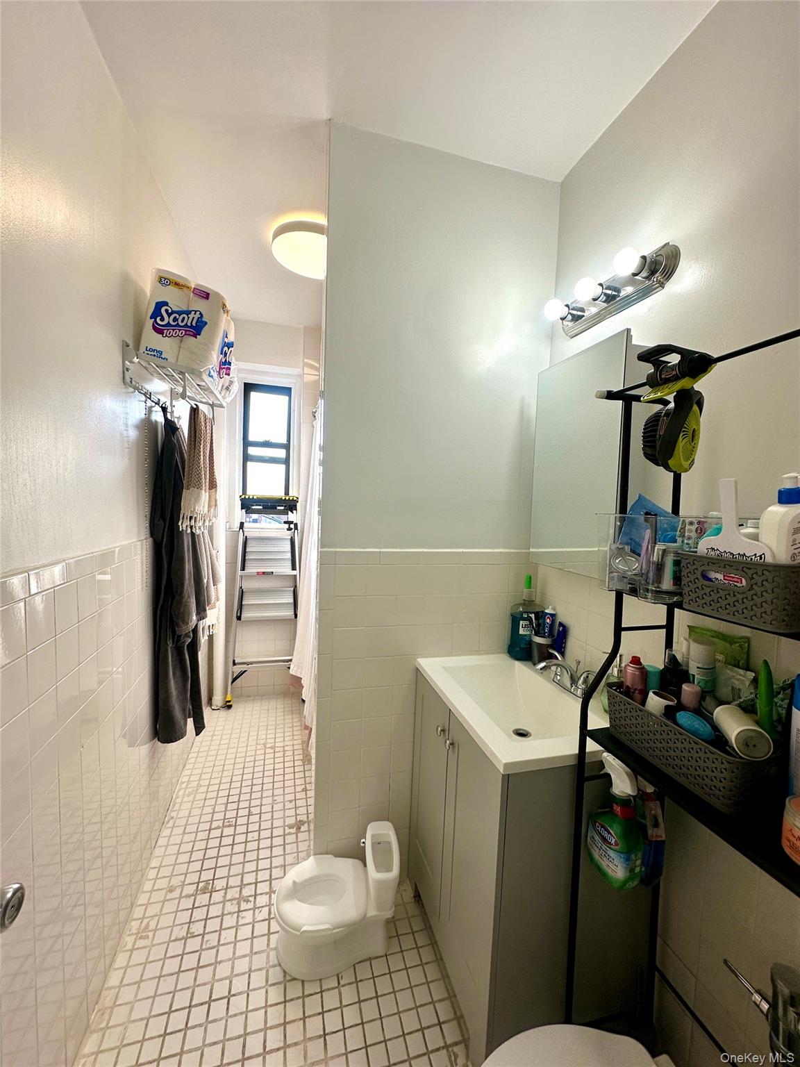 40-05 Ithaca Street, Unit 6D Queens, NY 11373 - Photo 10 of 10 Bathroom with tile walls, vanity, a wainscoted wall, a shower with shower curtain, and light tile patterned floors