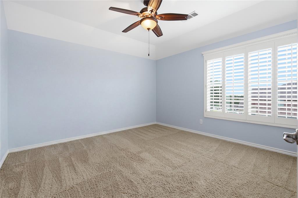 10001 Thurman Road Fort Worth, TX 76244 - Photo 30 of 40 Bedroom featuring neutral carpet flooring, blue painted walls, a tray ceiling, and a ceiling fan with integrated lighting