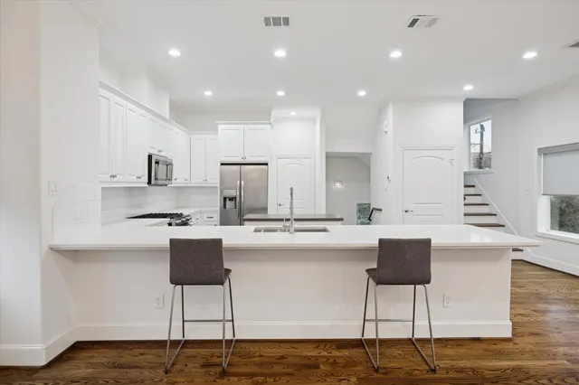 a kitchen with kitchen island stainless steel appliances a table and chairs in it