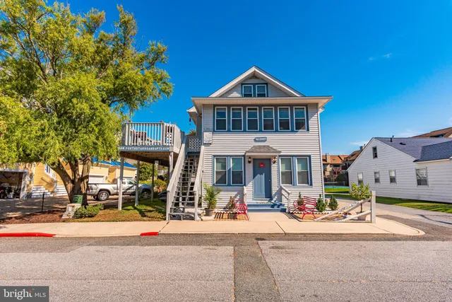 a view of a house with large windows and a small yard