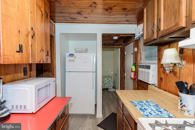 a view of a dining room and livingroom with furniture wooden floor a chandelier