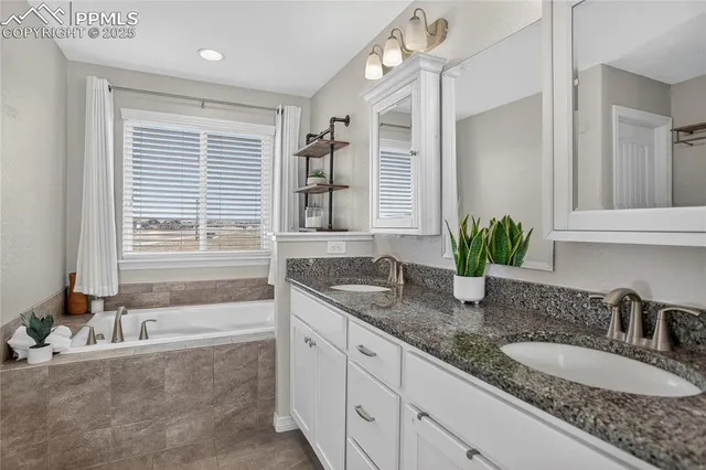 a bathroom with sink granite tub shower and mirror