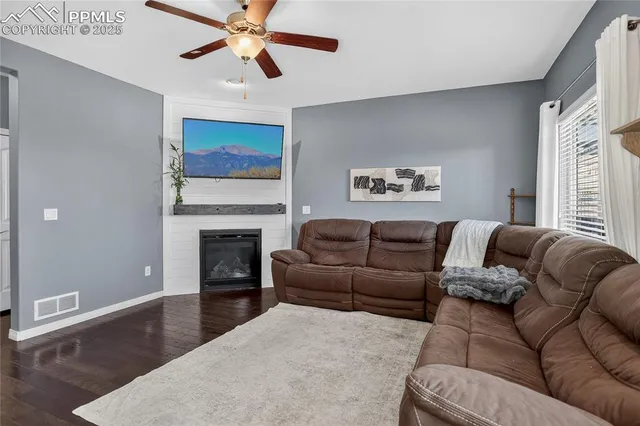 a living room with furniture a fireplace and a flat screen tv