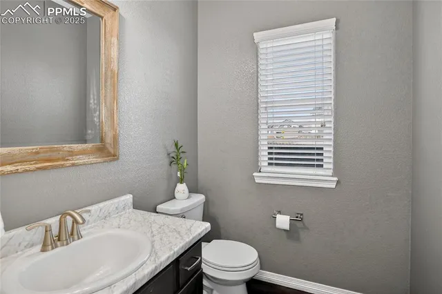 a bathroom with a sink a toilet and a window