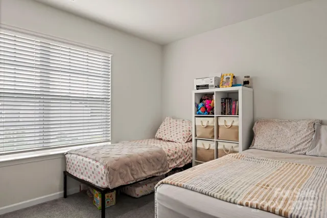 a bedroom with two beds and a window