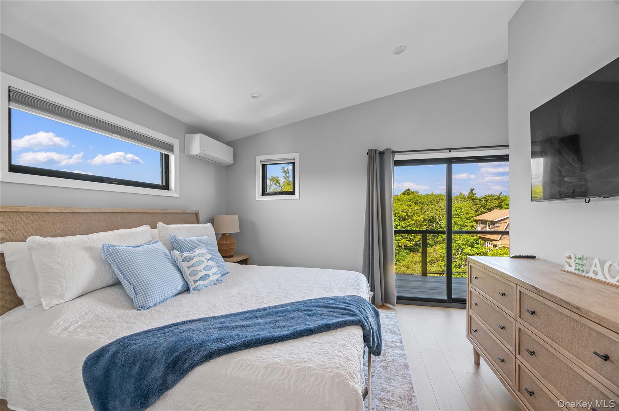 108 Ocean Road Ocean Beach, NY 11770 - Photo 11 of 23 Bedroom with vaulted ceiling, light wood finished floors, a wall mounted AC, and access to outside