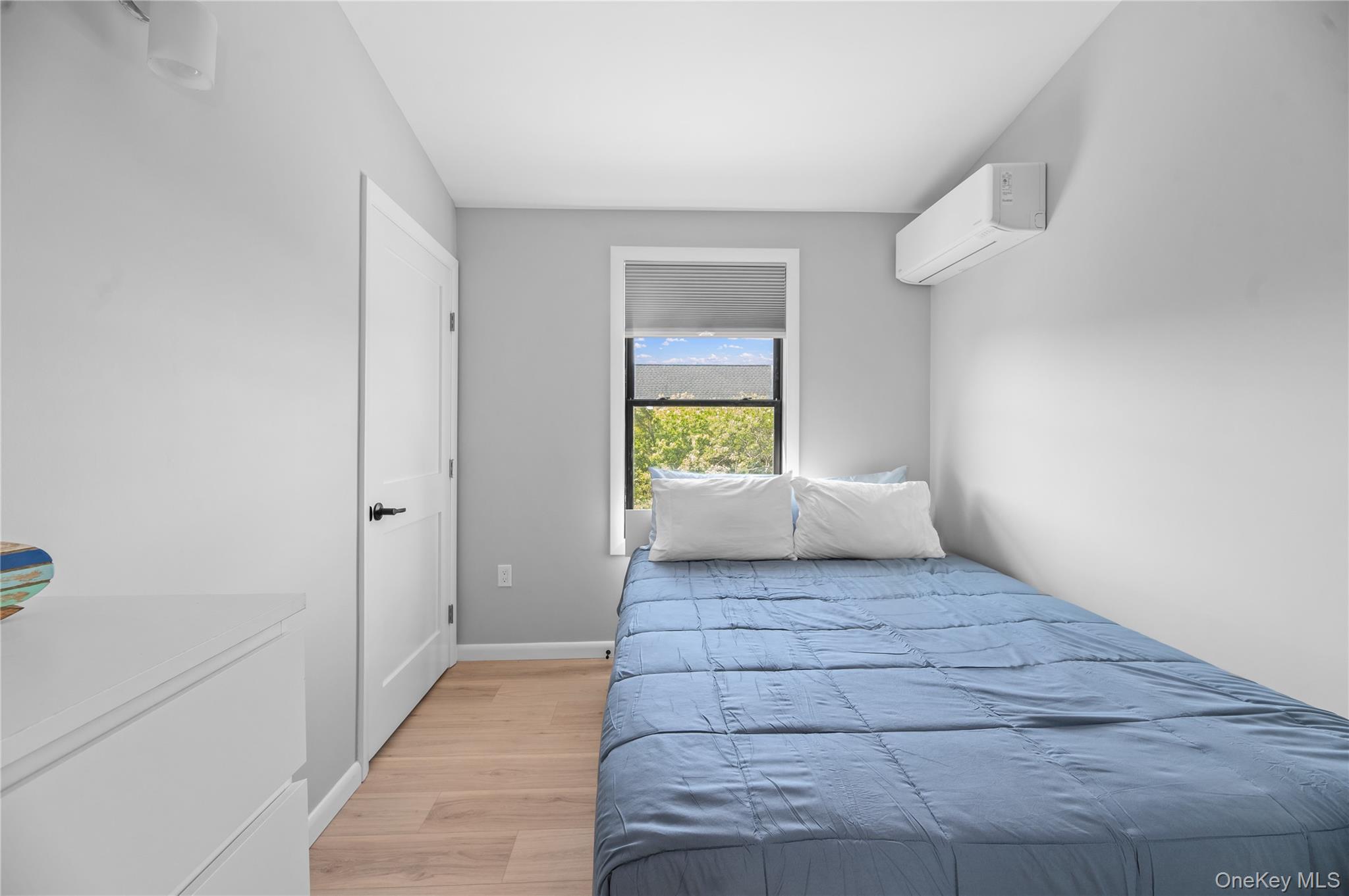 108 Ocean Road Ocean Beach, NY 11770 - Photo 14 of 23 Bedroom with light wood-style floors and an AC wall unit