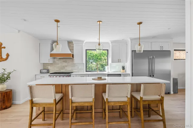 a kitchen with a table chairs refrigerator and cabinets