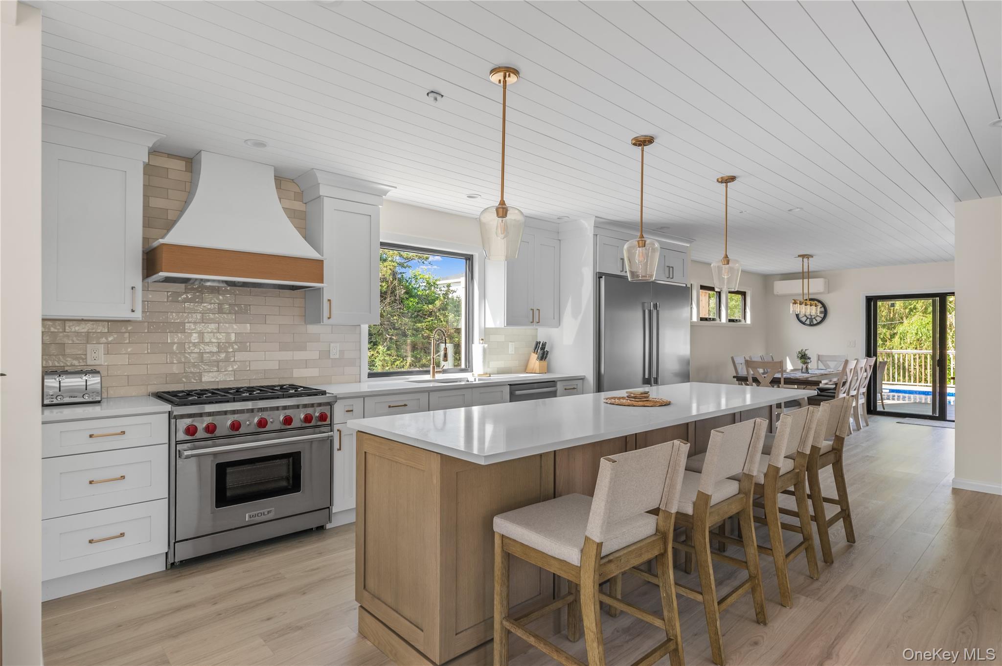 108 Ocean Road Ocean Beach, NY 11770 - Photo 6 of 23 Kitchen with high quality appliances, wooden ceiling, decorative backsplash, a kitchen breakfast bar, and a kitchen island