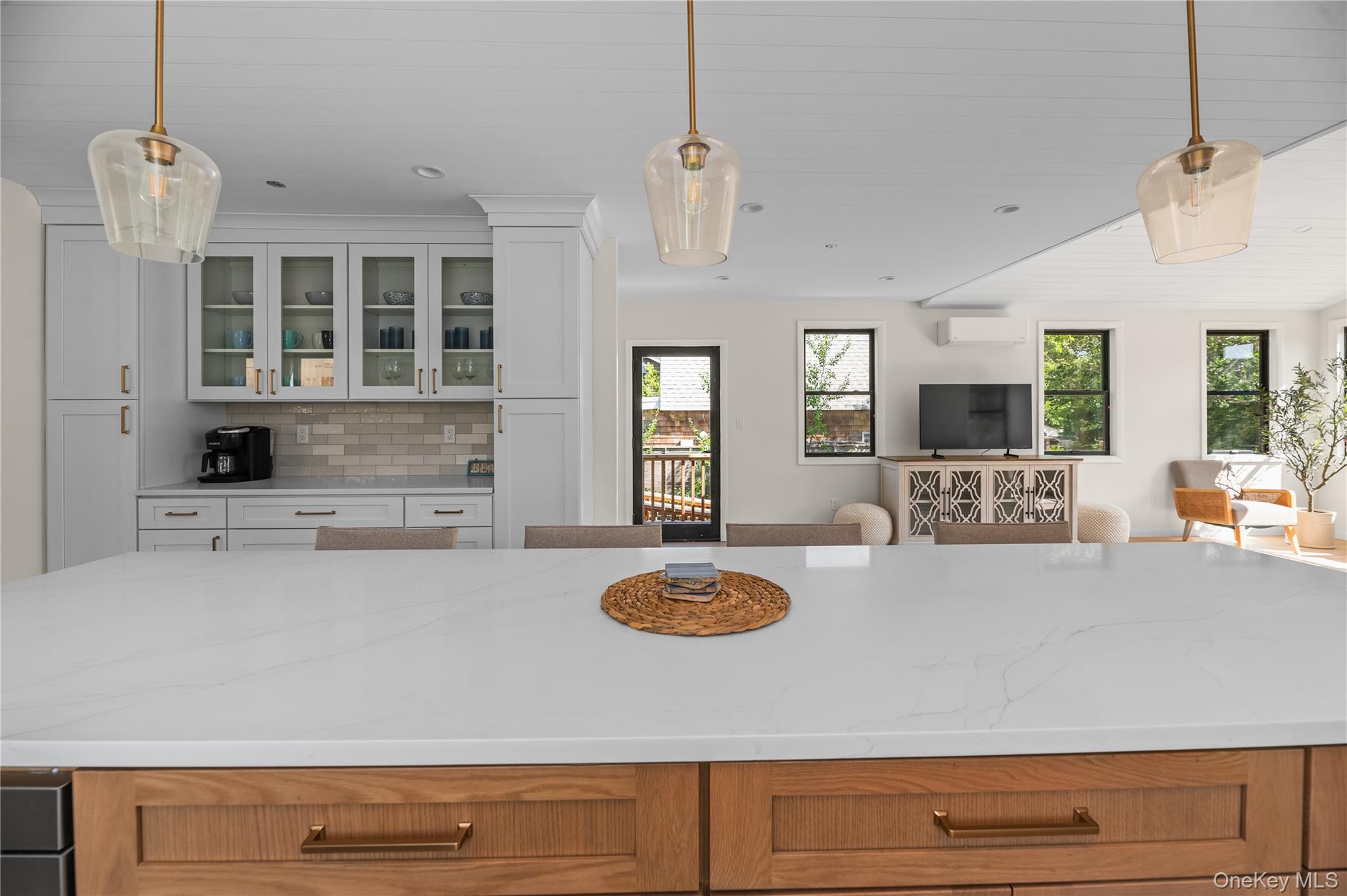 108 Ocean Road Ocean Beach, NY 11770 - Photo 22 of 23 Kitchen featuring pendant lighting, backsplash, open floor plan, and glass insert cabinets