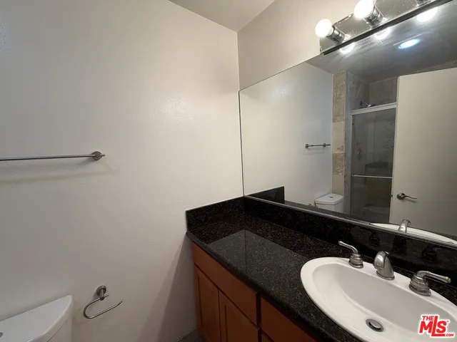 a bathroom with a granite countertop sink and a mirror