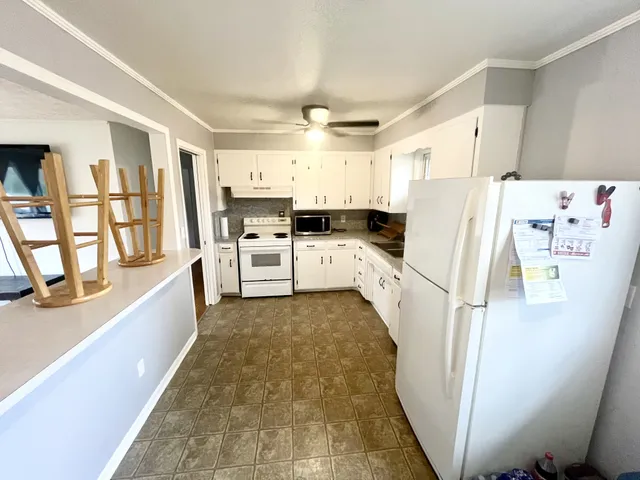 a kitchen with white cabinets and white appliances