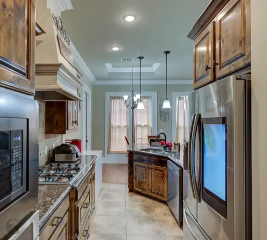 a kitchen with stainless steel appliances granite countertop a refrigerator and a stove