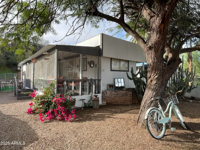 a front view of a house with a tree