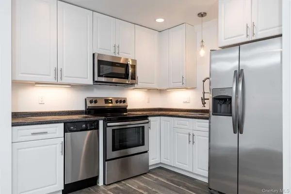 a kitchen with stainless steel appliances granite countertop a stove a refrigerator and a sink