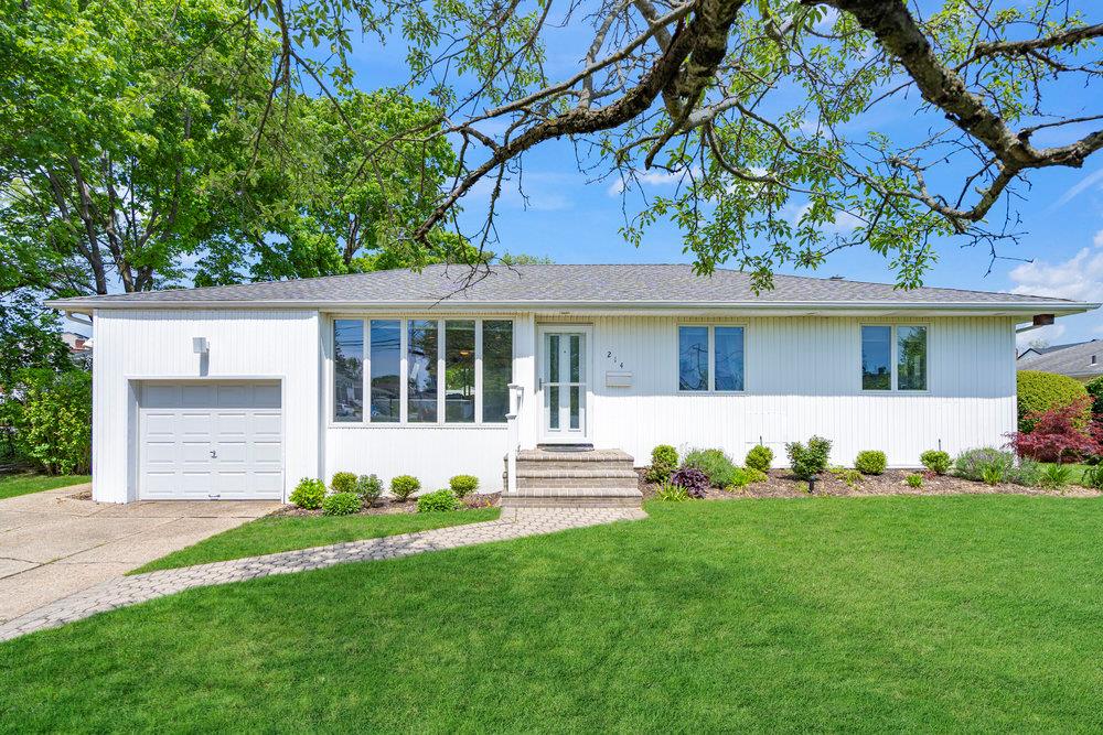 a front view of a house with a garden and yard