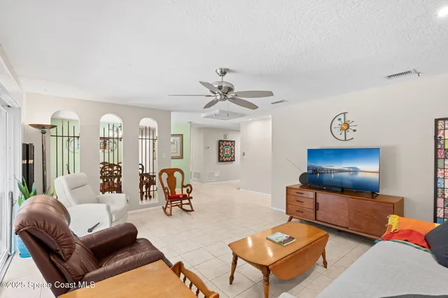 a kitchen with stainless steel appliances kitchen island granite countertop a refrigerator a sink dishwasher and white cabinets with wooden floor