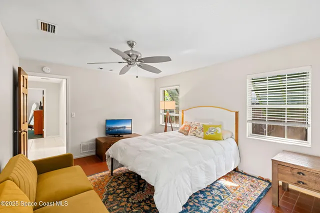 a spacious bedroom with a bed a couch and dresser