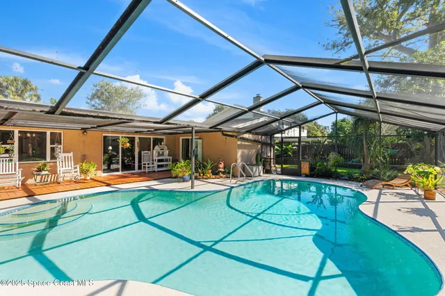 a view of a swimming pool with a patio and a yard
