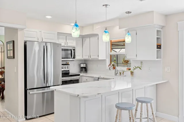 a kitchen with a refrigerator a sink and white cabinets