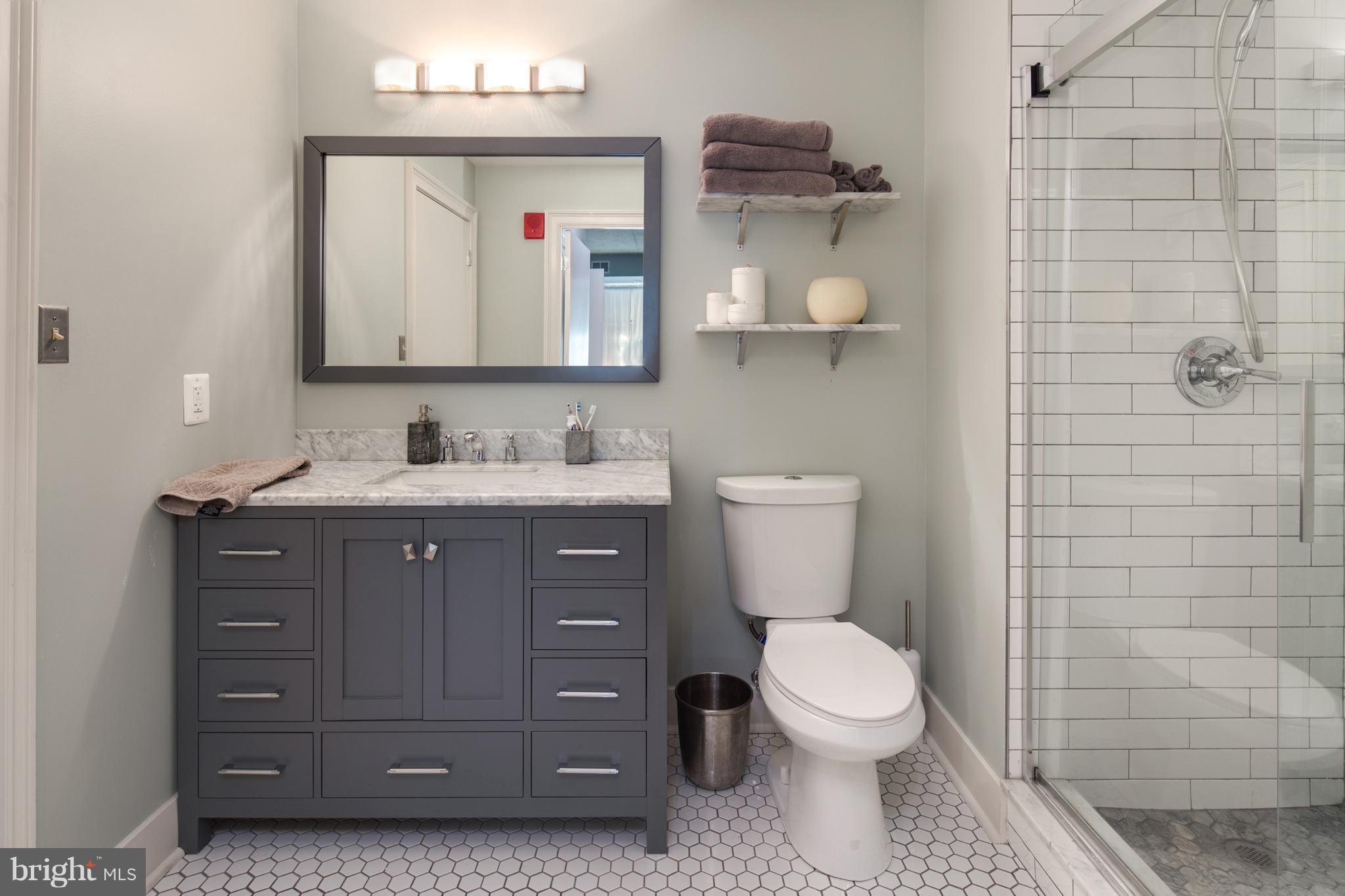 1300 N Street Northwest, Unit 4 Washington, DC 20005 - Photo 12 of 19 a bathroom with a toilet a sink and mirror