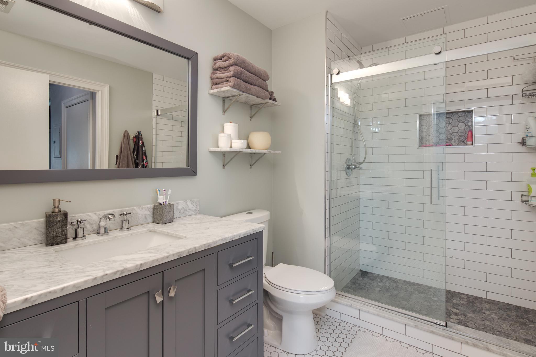1300 N Street Northwest, Unit 4 Washington, DC 20005 - Photo 13 of 19 a bathroom with a granite countertop toilet sink and mirror