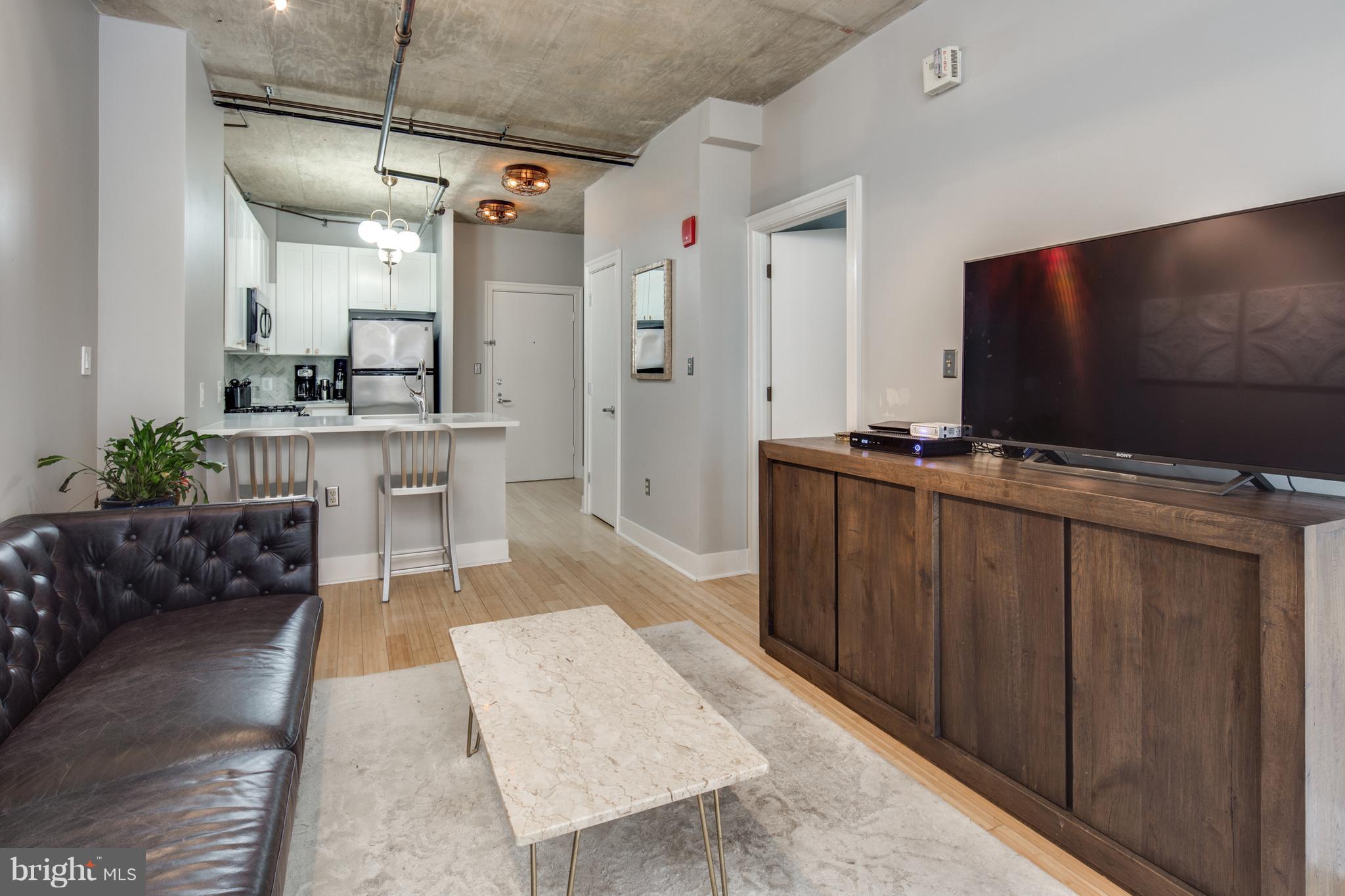 1300 N Street Northwest, Unit 4 Washington, DC 20005 - Photo 4 of 19 a living room with furniture and a flat screen tv