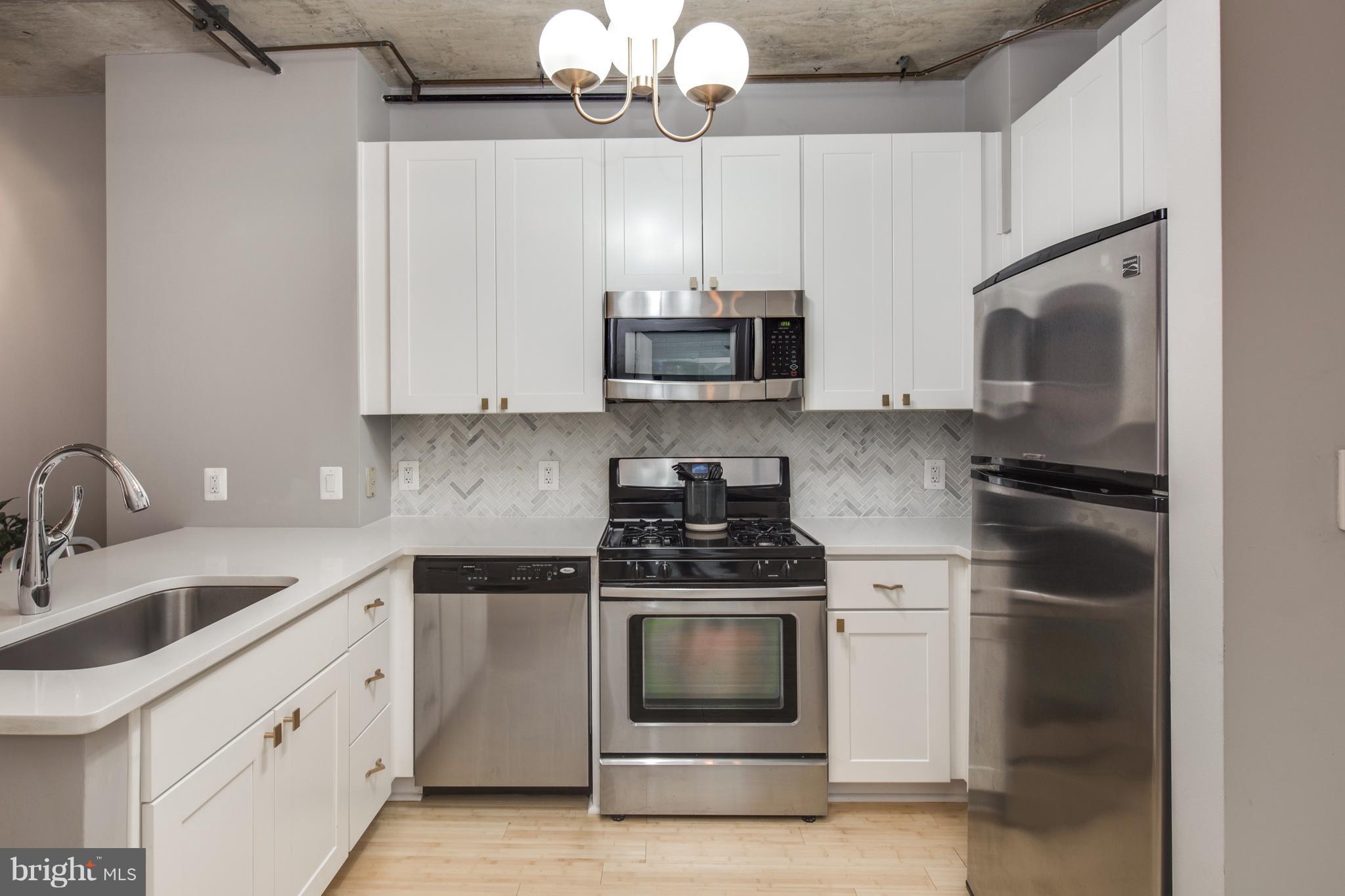 1300 N Street Northwest, Unit 4 Washington, DC 20005 - Photo 7 of 19 a kitchen with cabinets stainless steel appliances and a sink