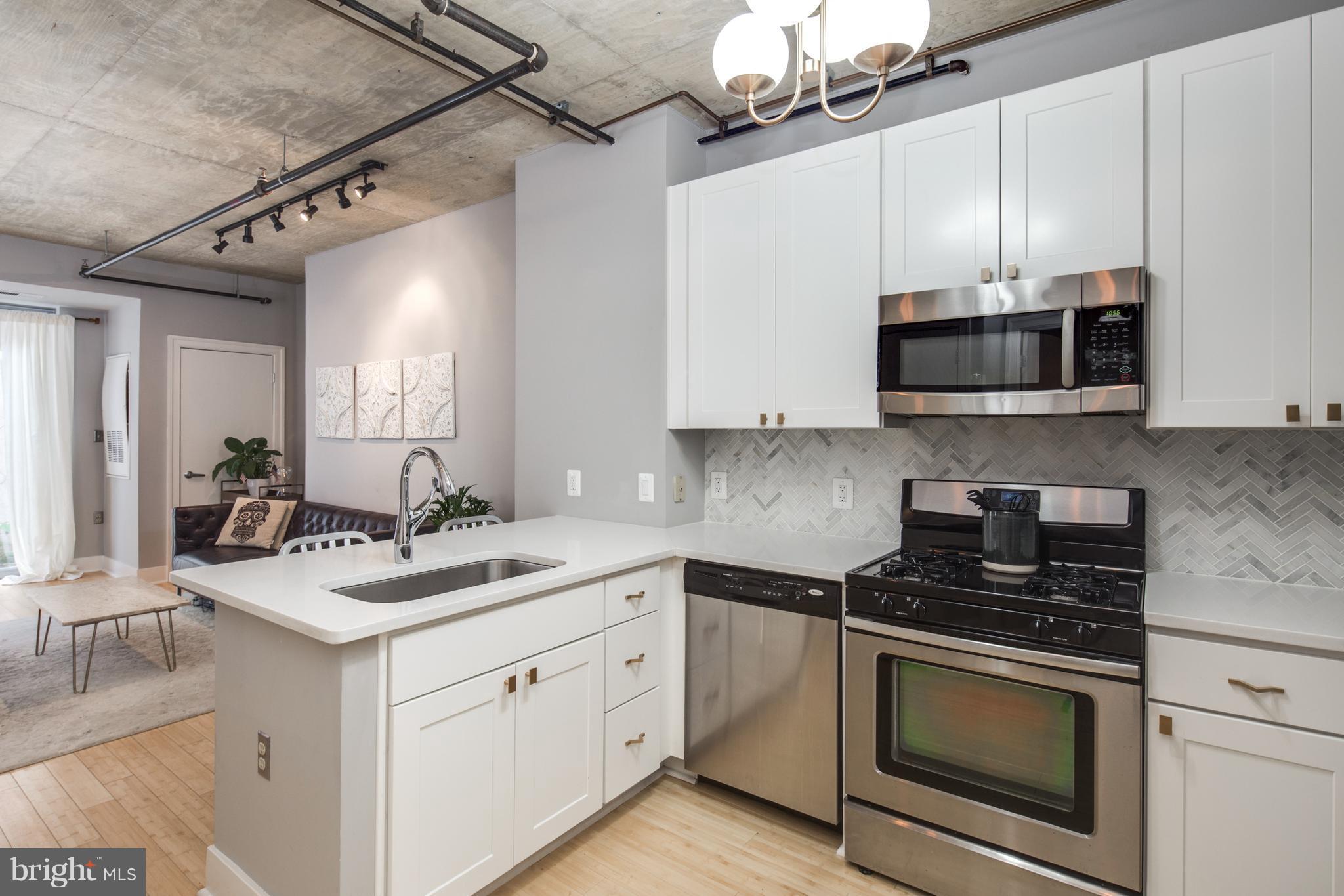1300 N Street Northwest, Unit 4 Washington, DC 20005 - Photo 8 of 19 a kitchen with stainless steel appliances a stove a sink and a microwave