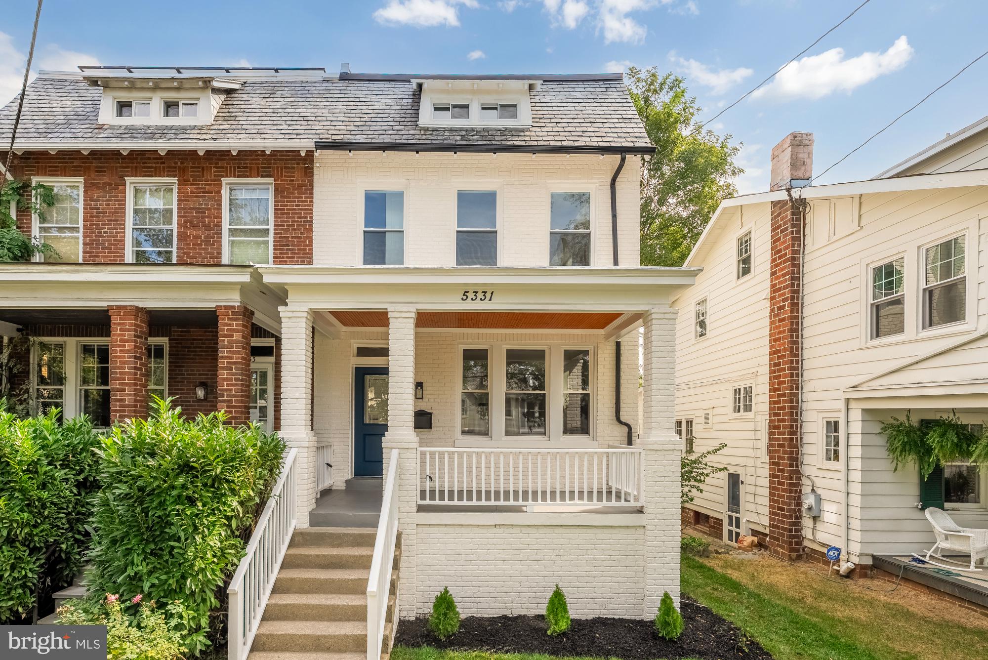 a front view of a building with a garden and plants
