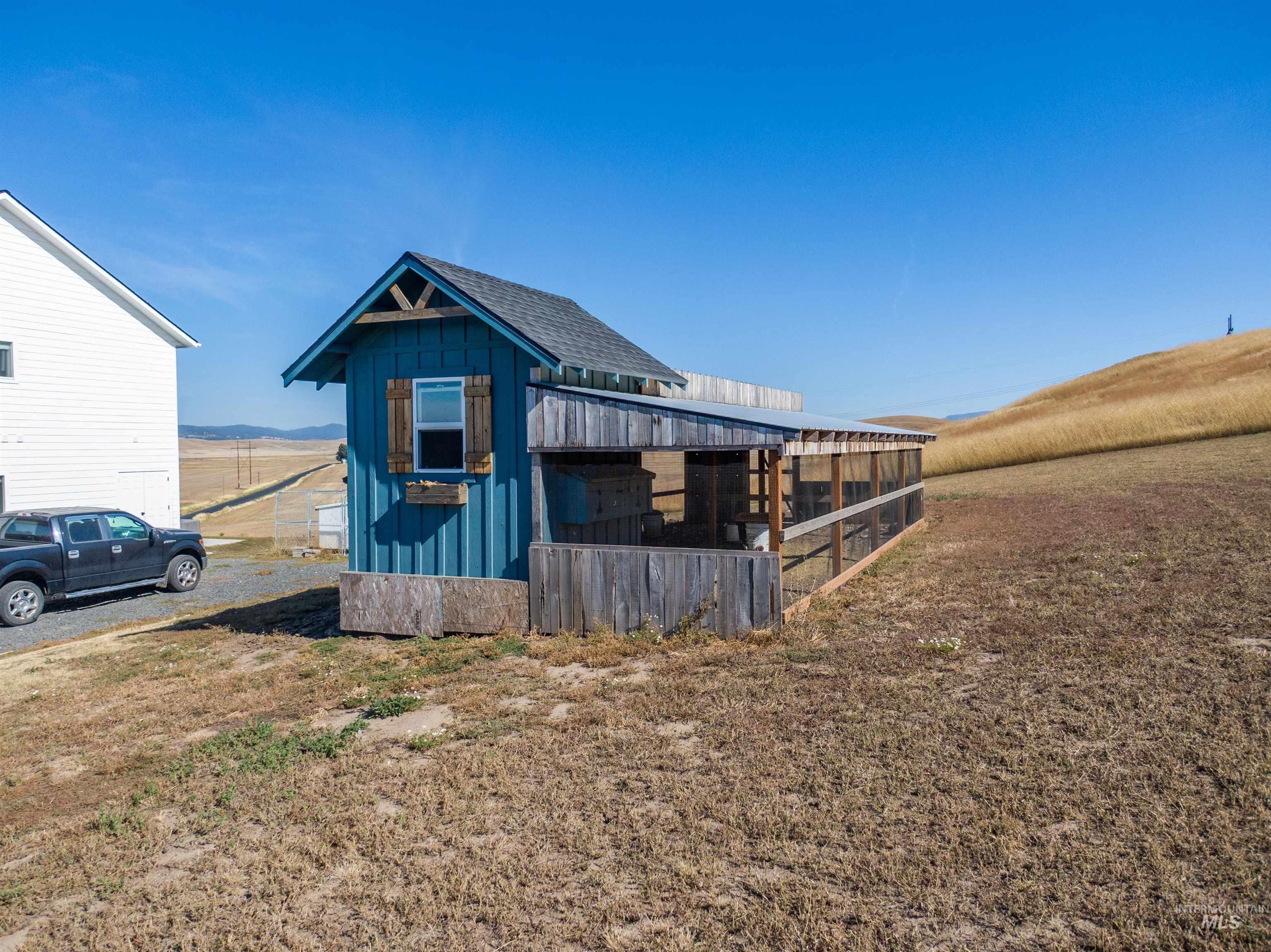 1032 Duffield Flat Road Potlatch, ID 83855 - Photo 43 of 50 Blue outbuilding with a window and a covered run