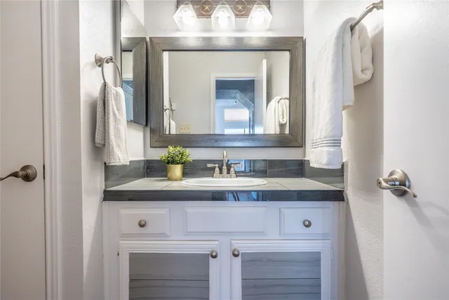 a bathroom with a sink vanity and a mirror