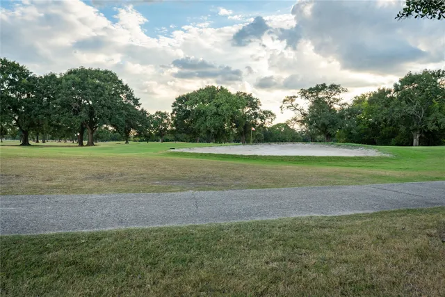 a view of a field with a big trees