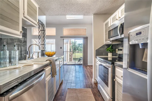 a kitchen with stainless steel appliances granite countertop a stove and a sink