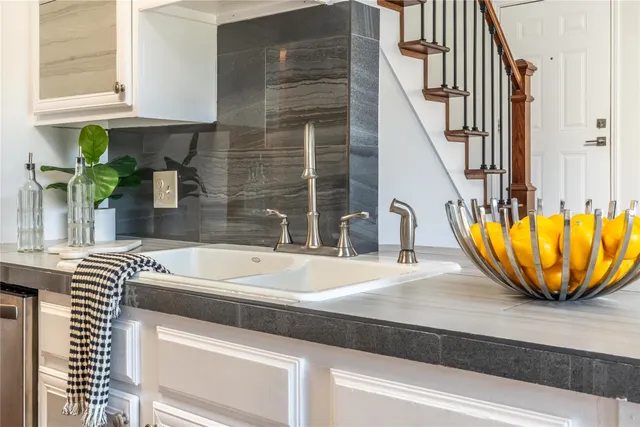 a sink with a granite top and a potted plant