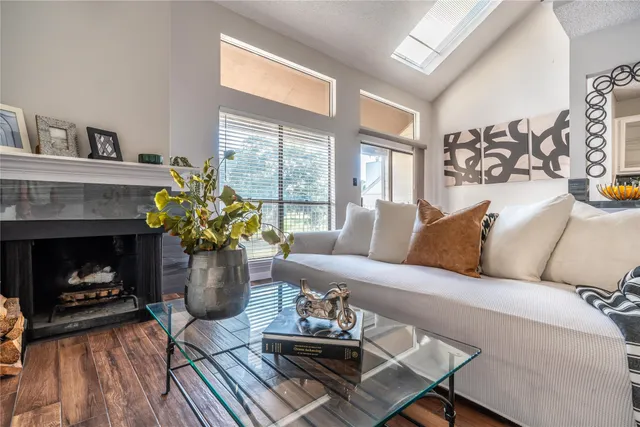 a living room with furniture a fireplace and a potted plant