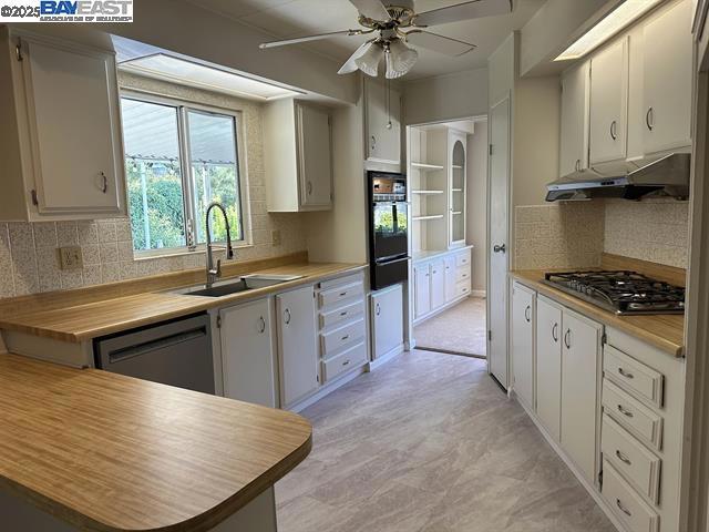 a kitchen with stainless steel appliances kitchen island granite countertop a stove a sink and a refrigerator
