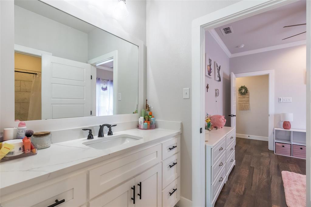 107 Kleingrass Road Abilene, TX 79606 - Photo 21 of 33 White shaker-style vanity with a single basin sink, white stone-finish countertop, and matte black faucet