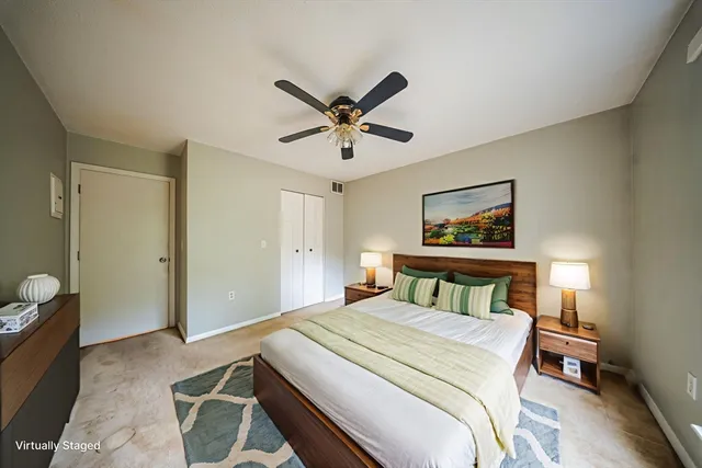 a bedroom with a bed a bookshelf and a potted plant