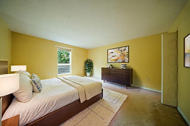 a spacious bedroom with a bed and a view of bathroom