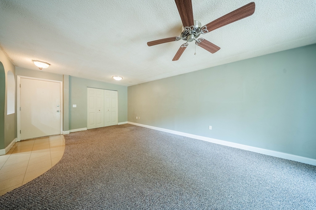 3 Shadowbrook Lane, Unit 3 Milford, MA 01757 - Photo 6 of 35 an empty room with a window and a fan