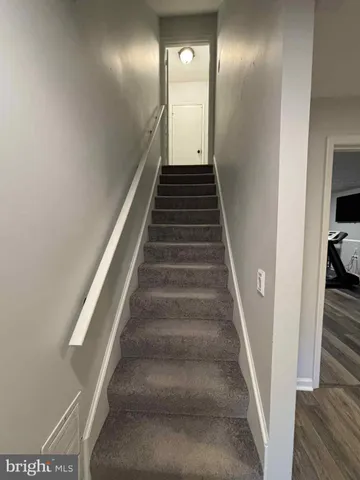 a view of a hallway with wooden floor and entryway