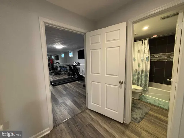 a view of a hallway view with wooden floor and living room