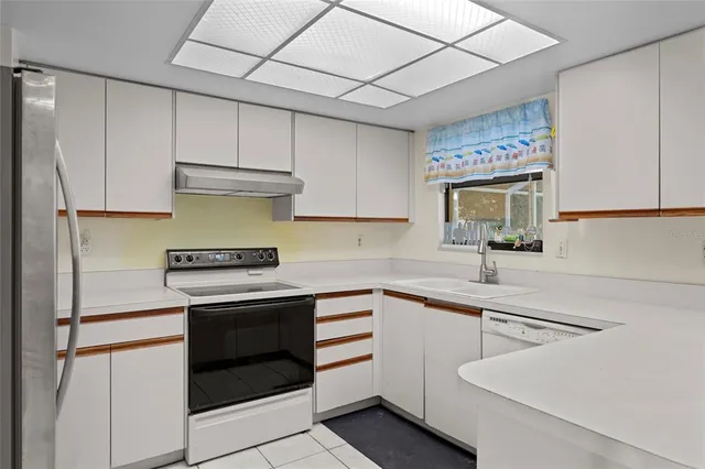 a kitchen with cabinets appliances a sink and a counter top space
