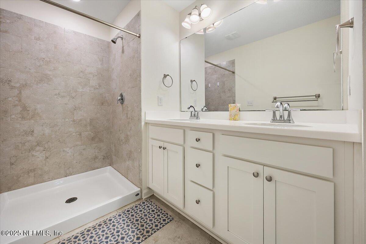 54 Ridge Lake Rd Street St. Augustine, FL 32086 - Photo 16 of 26 a bathroom with a double vanity sink a toilet a mirror and shower