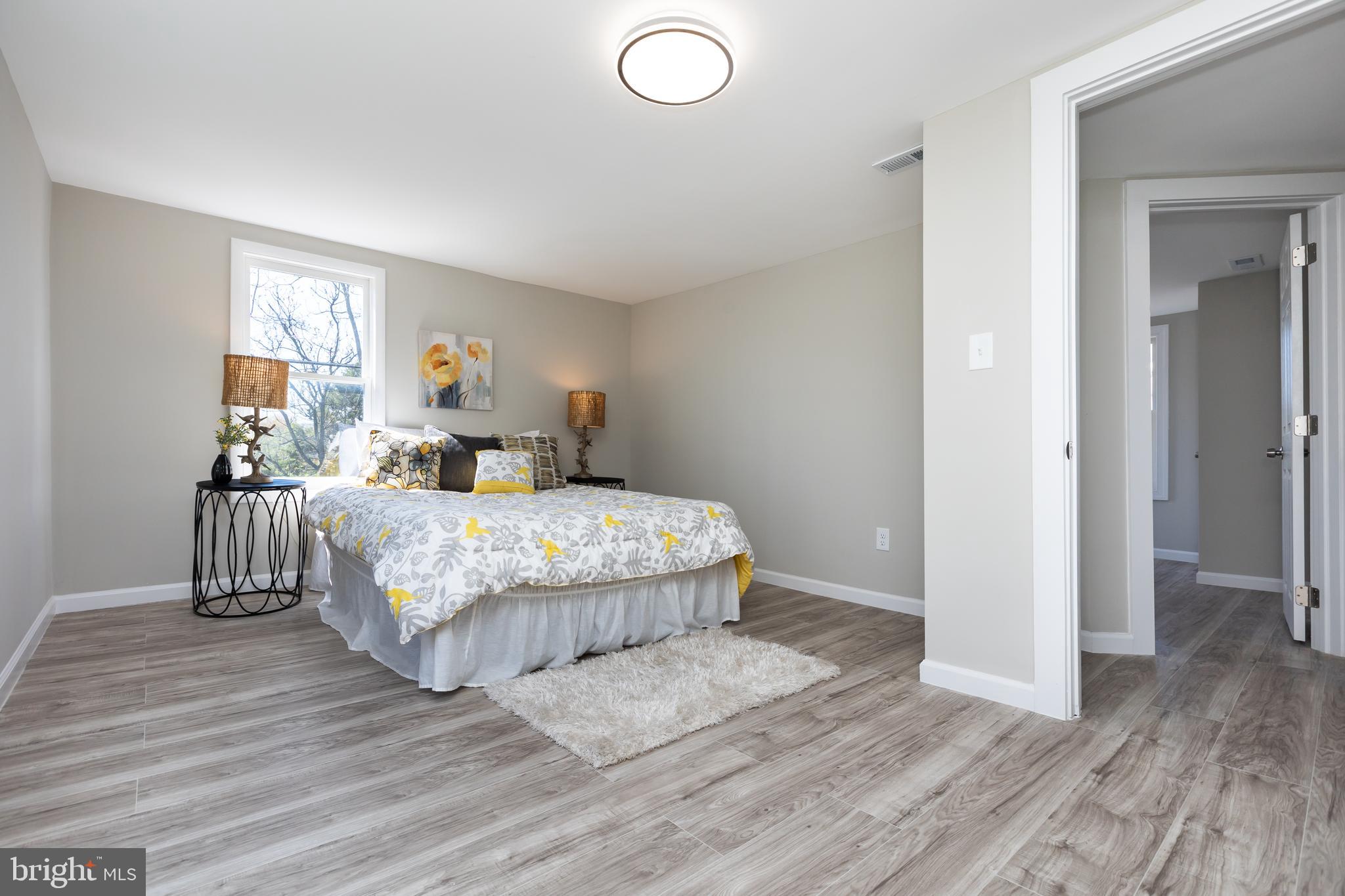 2407 Hammonds Ferry Road Halethorpe, MD 21227 - Photo 27 of 43 a bedroom with a bed and wooden floor