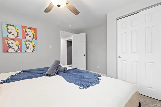 a bedroom with a bed and painting on the wall