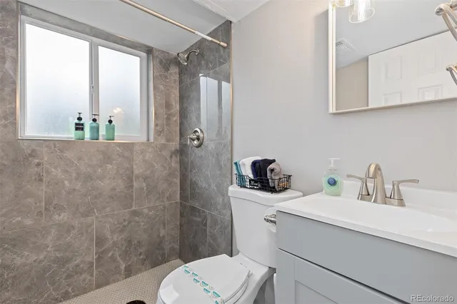 a bathroom with a sink a toilet and shower